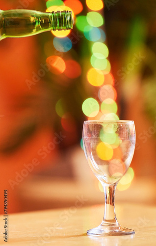 Bokeh, background and wine glass with bottle for drink, alcohol and glassware for party, celebration and lights. Cocktail, luxury and pour alcoholic beverage dinner with bright color and crystal
