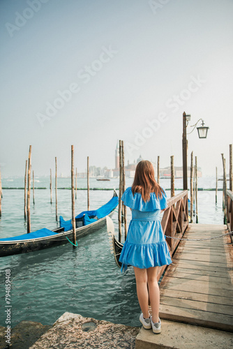 Beautiful young girl in a blue dress on the background of Venice