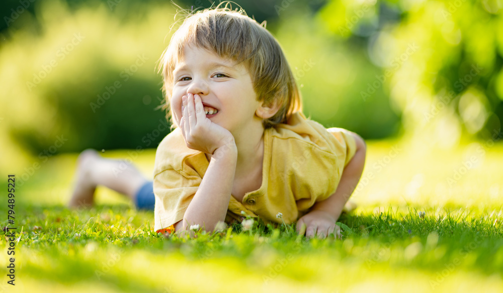 Adorable little boy having fun outdoors on sunny summer day. Kid running outdoors. Child exploring nature. Summer activities for small kids.