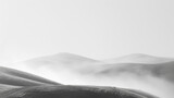 Delicate tendrils of mist drift lazily across the frame, adding an element of mystery to the minimalist landscape.