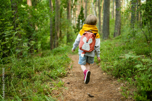 Foto Cute little boy with a backpack having fun outdoors on sunny summer day