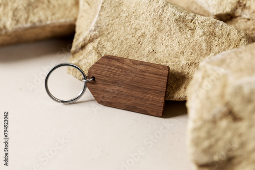 Vinatge wooden keyring near stones mockup. 3D rendering photo