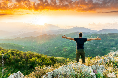 happy man watching amazing highland evening sunset, person delight with nature landscape