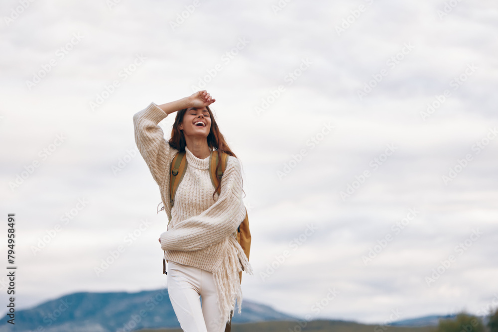 Adventurous Woman Smiling at the Mountain Cliff: A Stylish Journey of Freedom and Relaxation in Nature