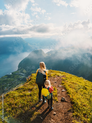 Family mother and child with backpack hiking in mountains together exploring Norway healthy lifestyle outdoor active vacations adventure tour, mom with daughter enjoying aerial fjord view © EVERST