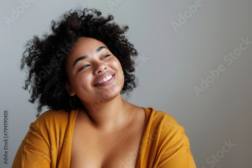 Portrait of a cheerful young woman with a lively smile, sporting a mustard yellow top and curly hair, exuding positivity and confidence. Generated AI