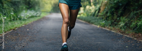 Sportswoman runner running on tropical park trail