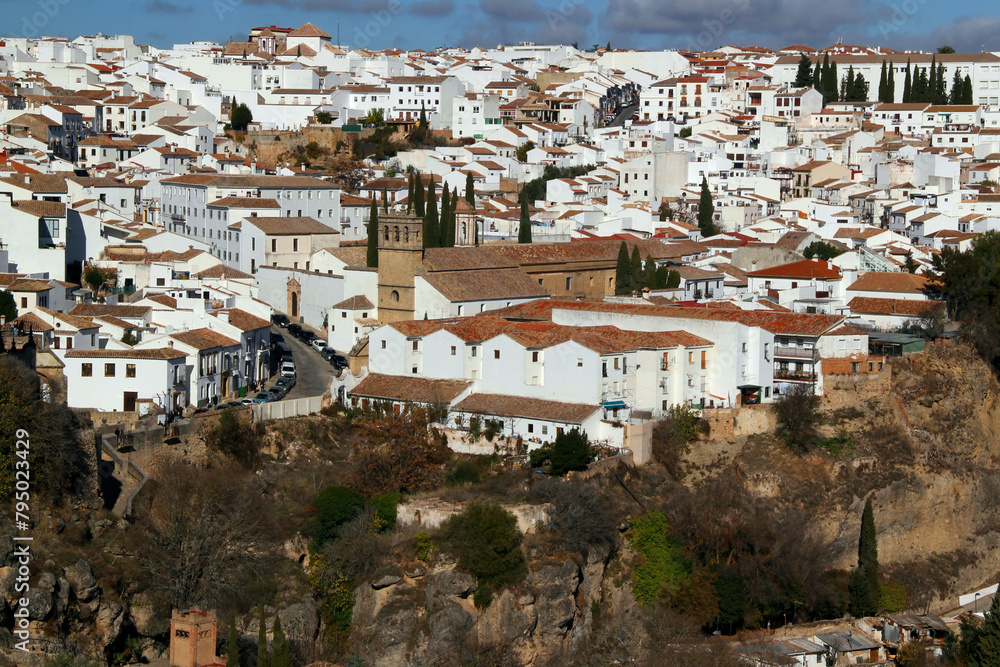 Panoramic view of the historic part of the city of Ronda with snow-white houses on the hill and a church in the center of the photo in the Andalusa region of southern Spain