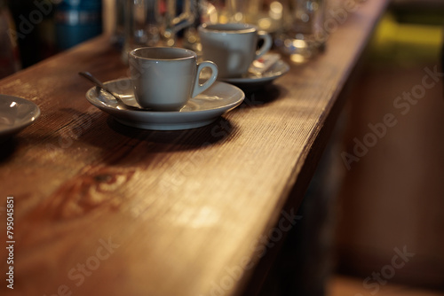 concetto di prendere o bere un caffè al bar. vista in primo piano di un bancone di legno con appoggiate sopra varie tazzine da caffè e dei bicchieri photo