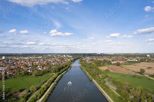 Boat sailing in river, seen from sky, surrounded by natural landscape of Mittellandkanal Hanover