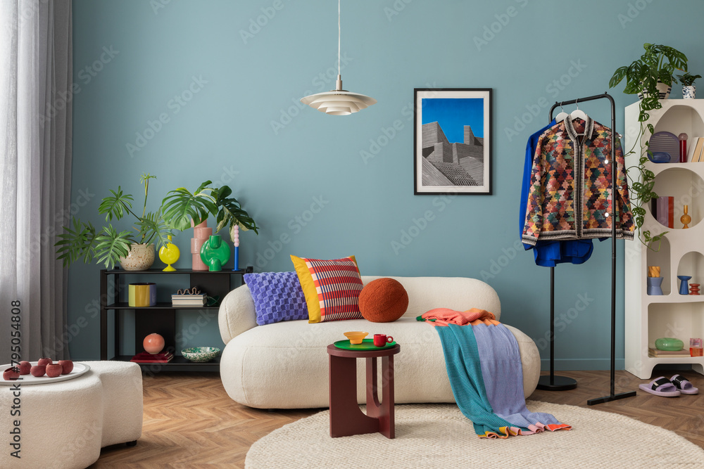 Fototapeta premium Modern and colorful interior of living room with design boucle sofa, mock up poster, shelf, plants, decorations and personal stuff. Home decor.