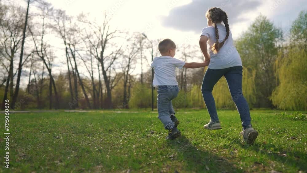 children running across the field. happy family child dream concept. a boy and a girl are running across a green field against the backdrop of a spring forest lifestyle. child's sporty children running across the field. happy family child dream concept. a boy and a girl are running across a green field against the backdrop of a spring forest lifestyle. child's sporty
