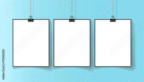 Three blank notepads hanging on clips against a turquoise background