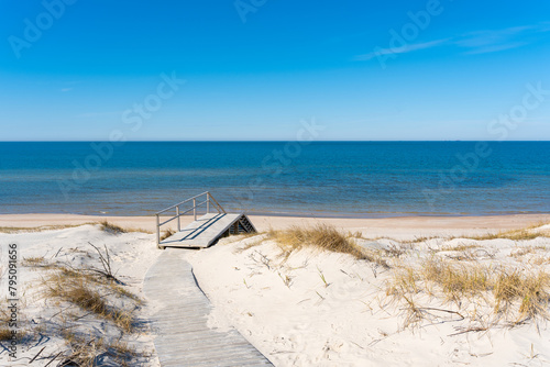 Fototapeta Naklejka Na Ścianę i Meble -  A wooden walking path leading to the stairs to the beach on the Curonian Spit on the Baltic Sea, Lithuania
