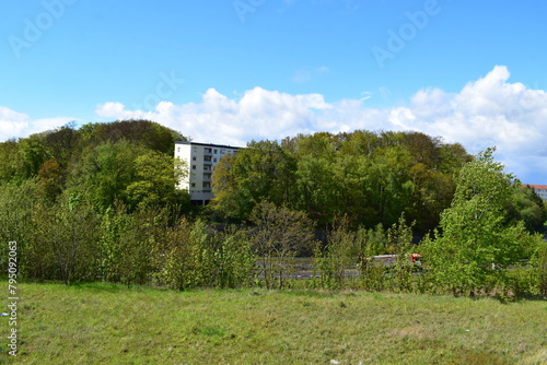 April weather clouds above a house between trees photo