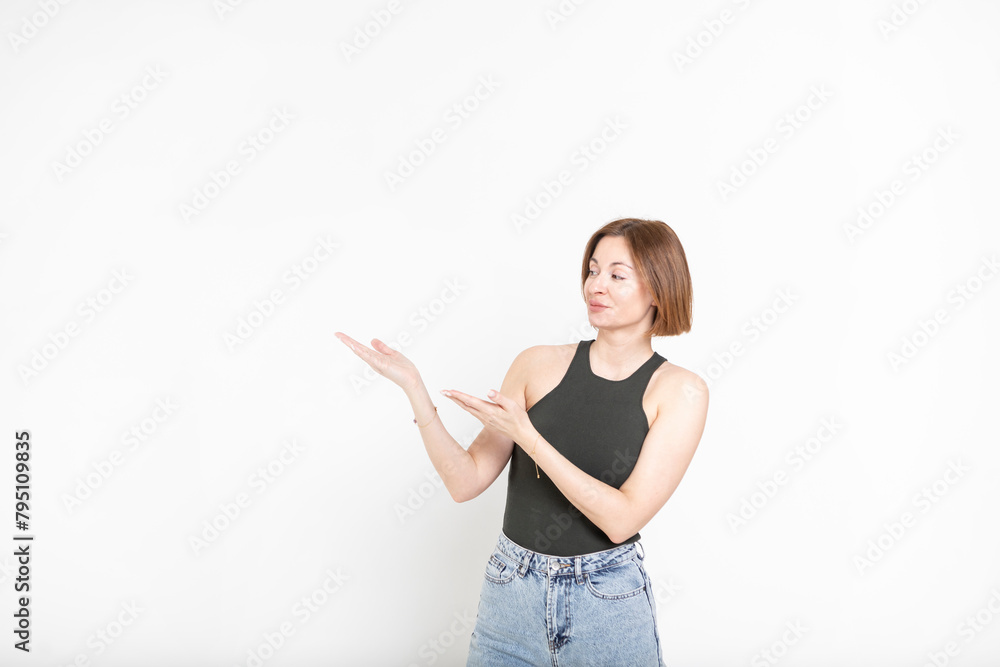 Young happy woman standing and pointing on empty space isolated on white background Young happy woman standing and pointing on empty space isolated on white background
