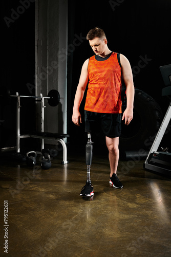 A man with a prosthetic leg, standing in a gym surrounded by exercise equipment.