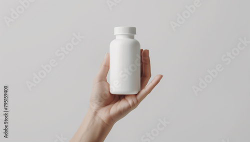 A person is holding a white pill bottle in their hand.  Concept of responsibility and care for one's health, as the person is holding the pill bottle 