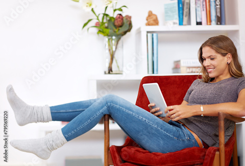 Movie, relax or happy woman on tablet in house with internet connection for film, video or research online. Smile, chair or girl on social media blog for technology, streaming or subscription in home photo