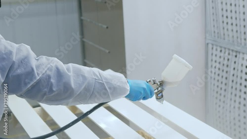 worker using spray gun and painting wood. Application of flame retardant ensuring fire protection, airless spraying. High quality 4k footage photo