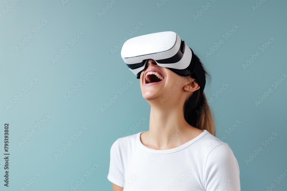 Happy young woman laughing while experiencing virtual reality with a modern VR headset, against a teal background. Excited Woman Trying VR Technology Happy young woman laughing while experiencing virtual reality with a modern VR headset, against a teal background. Excited Woman Trying VR Technology