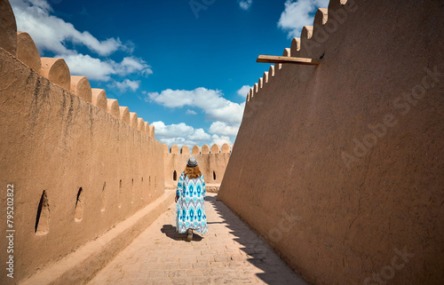 Tourist in ethnic dress at city walls Ichan Kala of Khiva photo