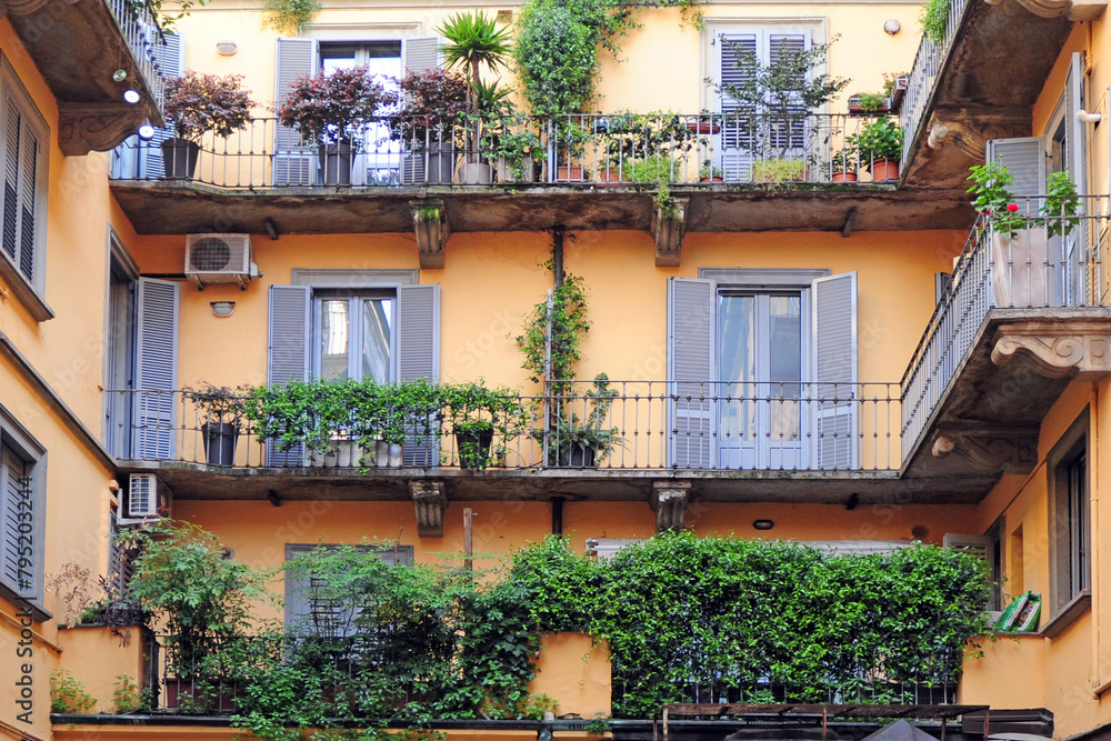 Typical yellow building of old Milan - houses with balcony and doors facing onto the landing - vintage house from the 50s and 60s - Milan fashion week and capital of design - real estate picture