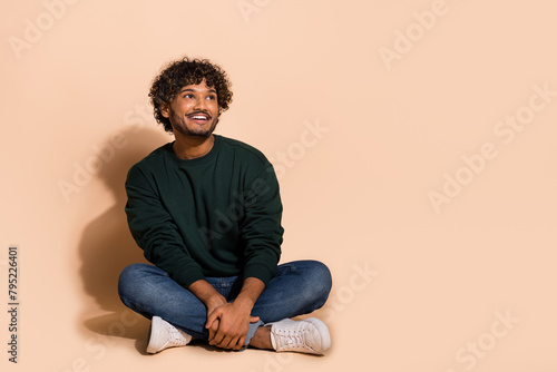 Full body portrait of nice young man look empty space wear sweater isolated on beige color background © deagreez