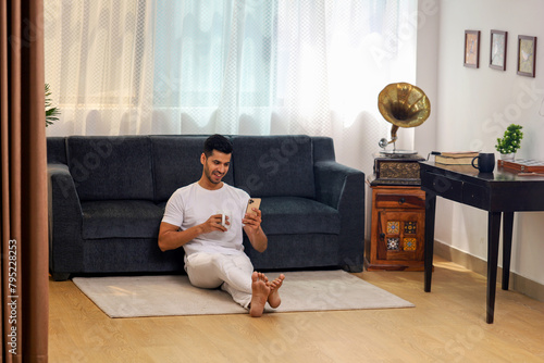 Handsome Man Sitting With Legs Crossed On Floor 