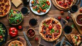 Pizza party dinner. Flat-lay of various kinds of Italian pizza, salad and red wine in glasses over rustic wooden table, top view, wide composition. Fast food lunch, celebration, gathering concept