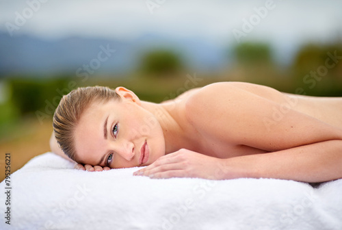 Relax  portrait and woman lying for spa treatment  wellness or body care on massage bed. Smile  therapy and female person at luxury resort for stress relief  comfort or pamper on tropical holiday