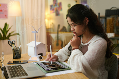 Teenage girl enrolling in online course via application on tablet © DragonImages