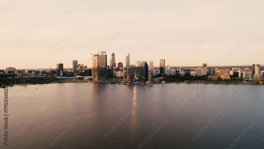A city skyline bathed in the warm light of sunset, with skyscrapers reflecting on the calm surface of an adjacent river or lake. A city skyline bathed in the warm light of sunset, with skyscrapers reflecting on the calm surface of an adjacent river or lake.