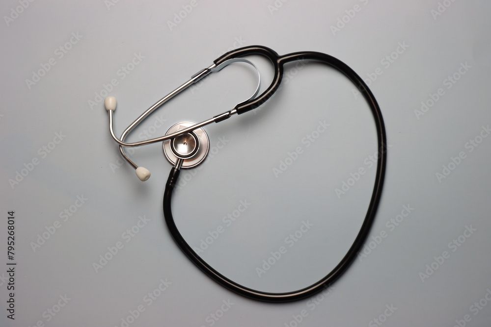 Black Stethoscope in a grey background in a top view Black Stethoscope in a grey background in a top view