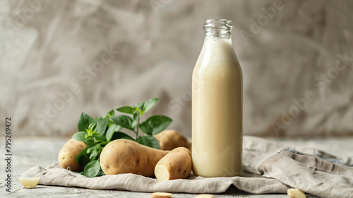 Bottle of tasty potato milk on light background