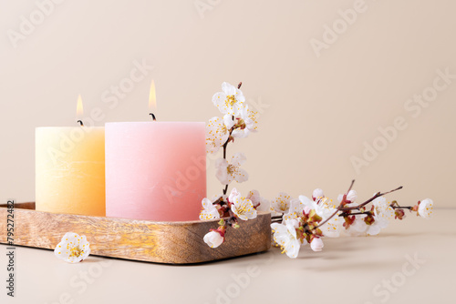 Burning candles and cherry blossom twig, spa still life