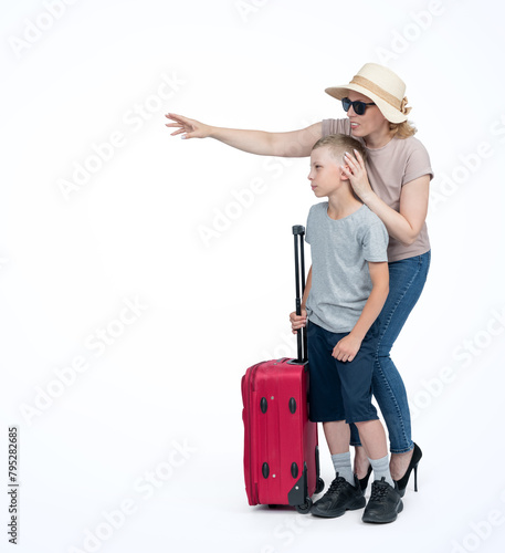 Family, mom in sunglasses and hat with a red suitcase, shows her son the purpose of the trip, isolated on a light blue background
