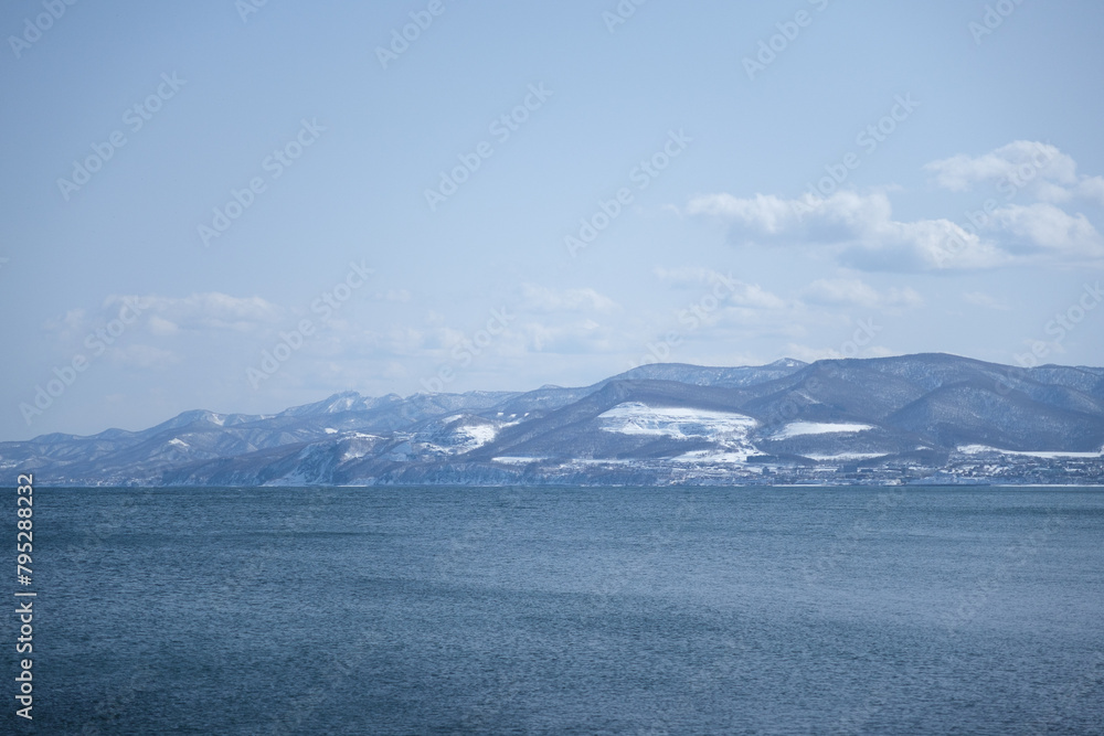 海と雪の積もった山 北海道