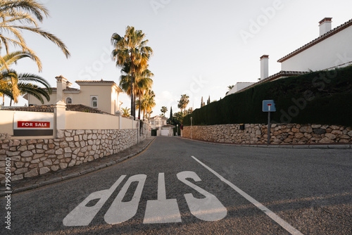 A serene suburban street lined with palm trees features a house for sale, evoking the prospect of a new beginning in a sunny locale, costa del sol, Spain, marbella