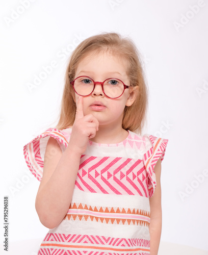Thoughtful little girl with glasses on a white background