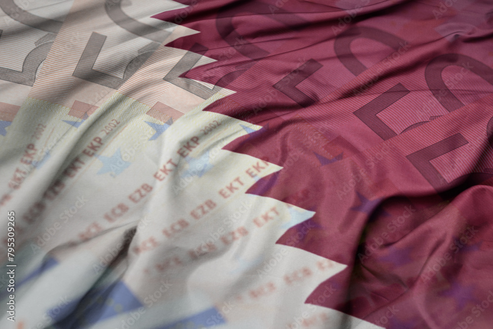 waving colorful national flag of qatar on a euro money banknotes background. finance concept. waving colorful national flag of qatar on a euro money banknotes background. finance concept.