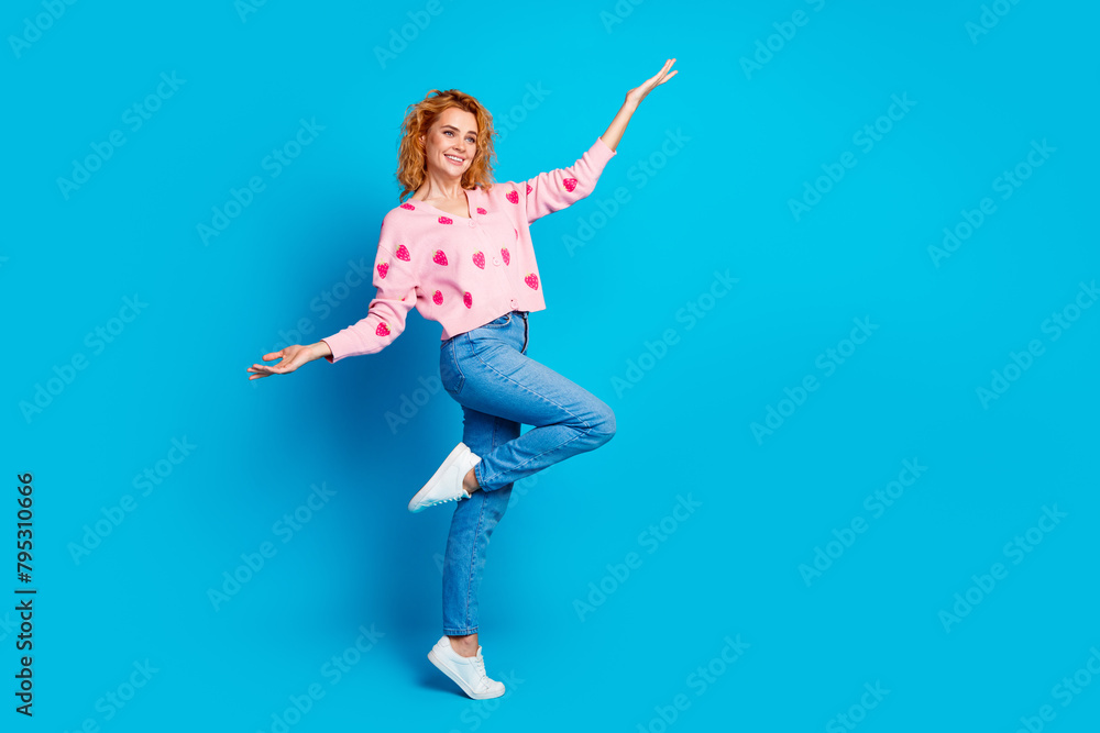 Full length photo of attractive woman playful have fun look empty space dressed stylish pink clothes isolated on blue color background