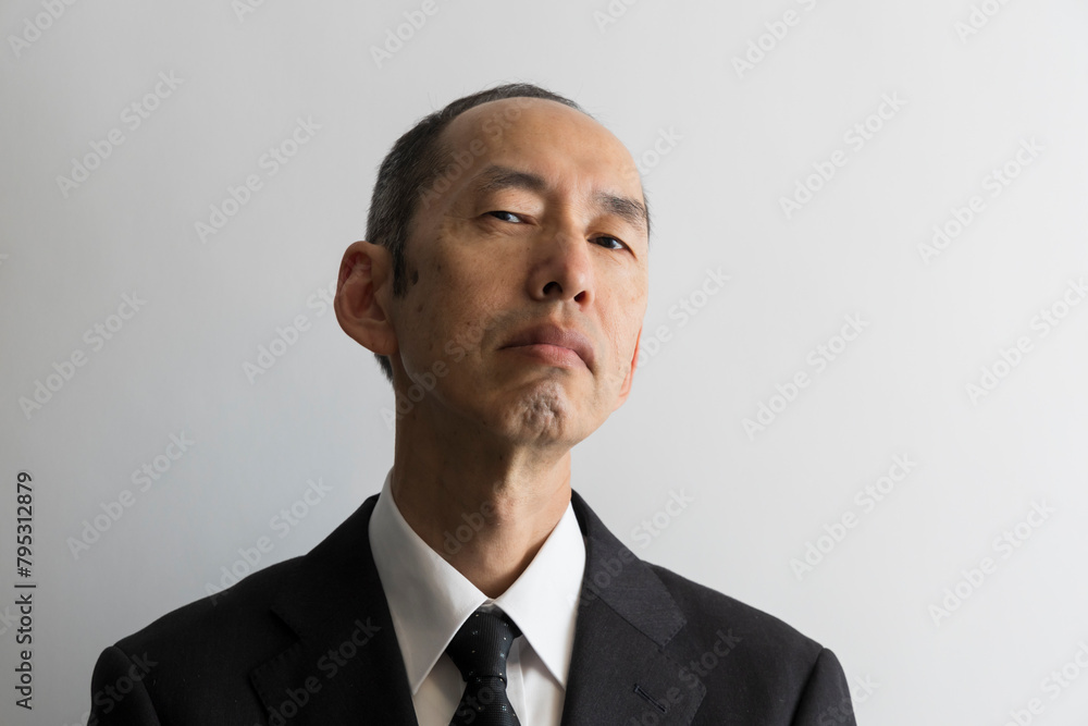 上から目線で睨むスーツ姿の日本人の中年男性のポートレイト 上から目線で睨むスーツ姿の日本人の中年男性のポートレイト