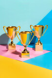 Gold trophies on a color background, to represent success