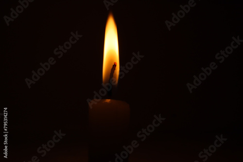 Glowing candle flame in the dark