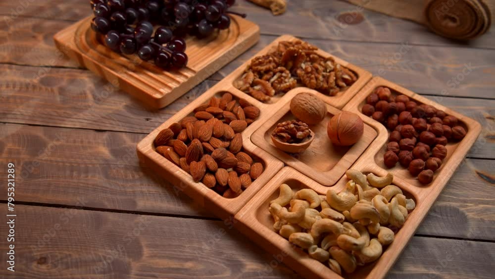 Two trays are filled with a variety of nuts and raisins, neatly arranged in separate sections. The camera pans over the trays, showcasing the different types and quantities of nuts and raisins. Two trays are filled with a variety of nuts and raisins, neatly arranged in separate sections. The camera pans over the trays, showcasing the different types and quantities of nuts and raisins.