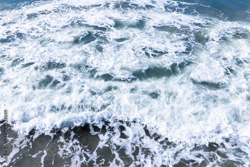 Sea water with waves and foam, abstract natural background photo