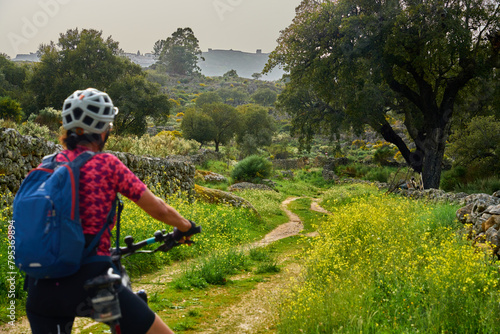 active senior woman cycling with her electric mountain bike in the rough landscape of National Parc Serra de São Mamede near Marvao in central Portugal, Europe