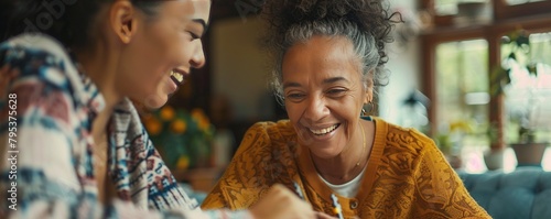 A smiling female caregiver aids a senior woman with a puzzle at home, depicting companionship and assistance. photo