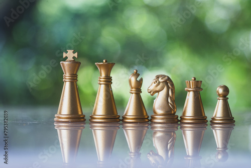 Gold chess pieces in a row on a natural background. Can use to display or montage on product